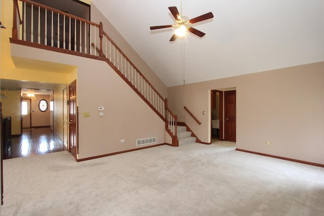 unfurnished living room with high vaulted ceiling, light colored carpet, and ceiling fan