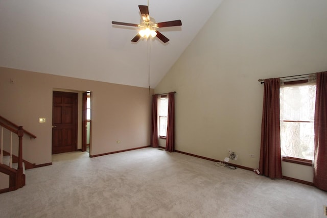 unfurnished living room with ceiling fan, light colored carpet, and high vaulted ceiling