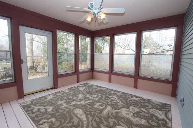 unfurnished sunroom featuring ceiling fan