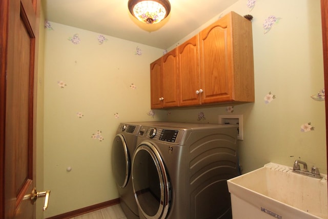 clothes washing area featuring cabinets, separate washer and dryer, and sink