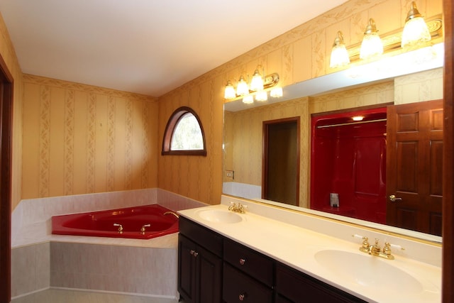 bathroom with vanity and tiled tub