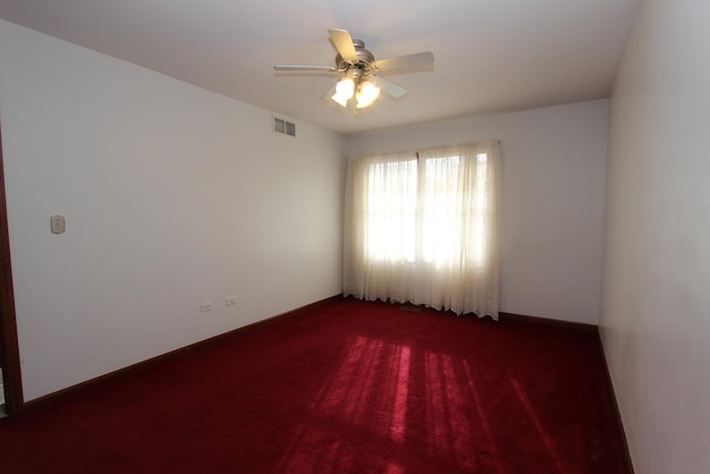 empty room with dark carpet and ceiling fan