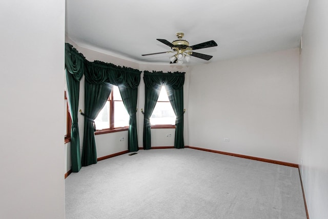 carpeted spare room featuring ceiling fan