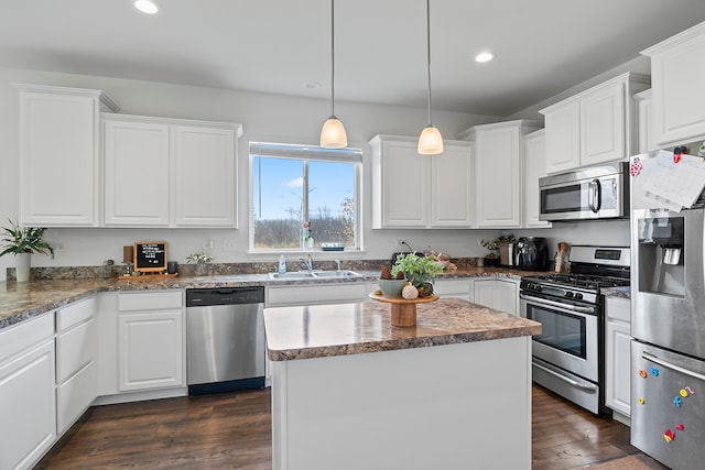 kitchen featuring white cabinets, a kitchen island, stainless steel appliances, and dark wood-type flooring