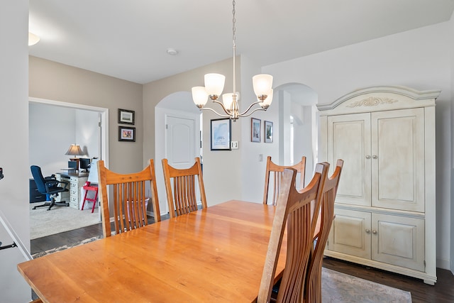 dining space featuring dark hardwood / wood-style flooring and a chandelier