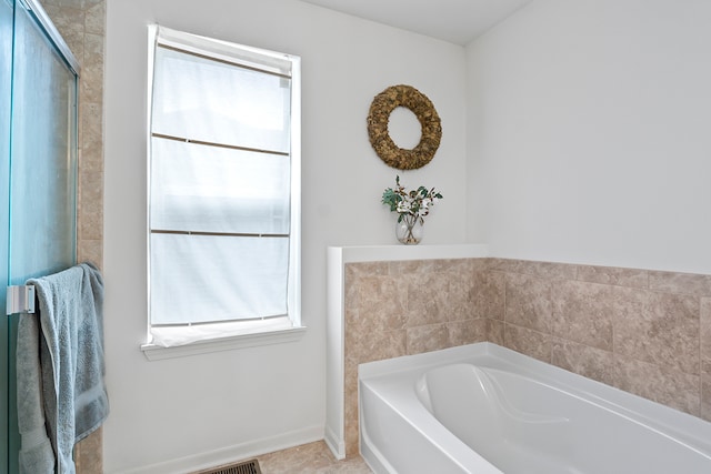 bathroom featuring tile patterned floors, a wealth of natural light, and shower with separate bathtub