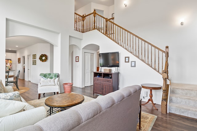 living room featuring a high ceiling and dark hardwood / wood-style floors