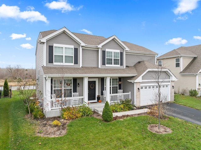 view of front of home with a front yard, a porch, and a garage