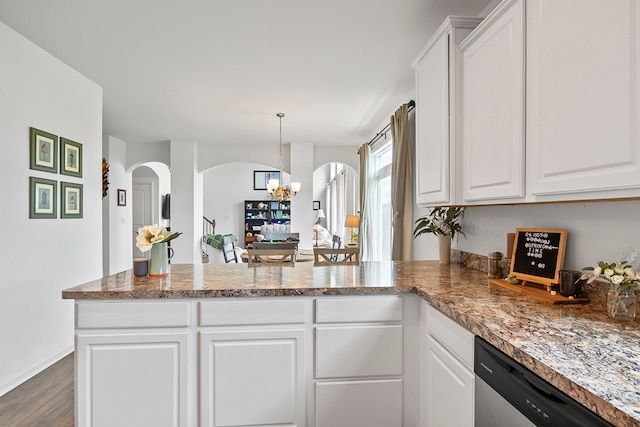 kitchen with kitchen peninsula, stainless steel dishwasher, a notable chandelier, dark hardwood / wood-style floors, and white cabinetry