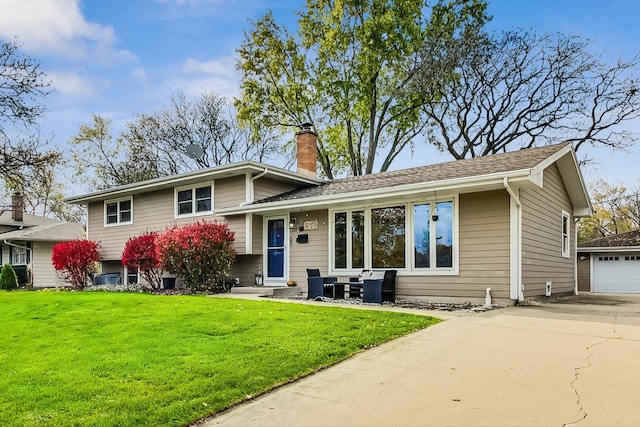 view of front of property featuring a garage, an outdoor structure, and a front yard