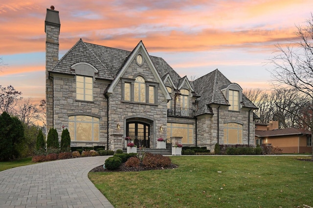 french country inspired facade with a lawn and french doors