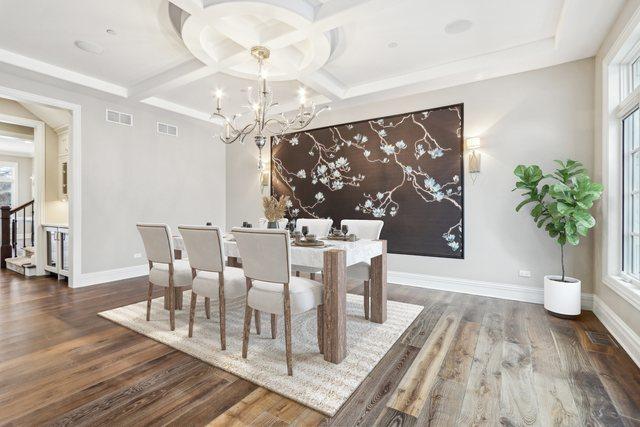 dining space with dark hardwood / wood-style flooring, coffered ceiling, and a notable chandelier