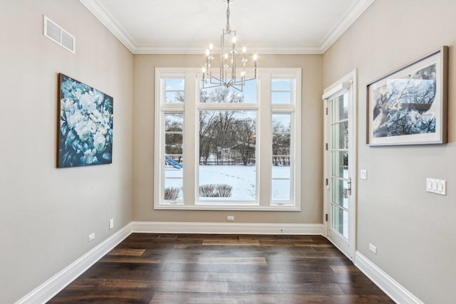 unfurnished dining area featuring dark wood-type flooring, ornamental molding, and a chandelier