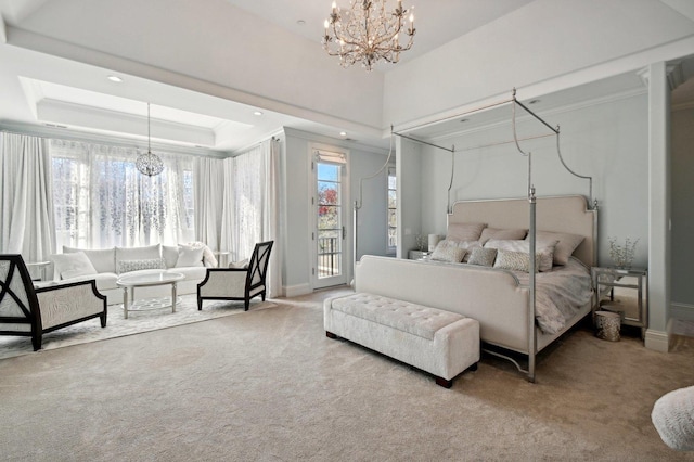 bedroom featuring access to exterior, multiple windows, a raised ceiling, and a notable chandelier