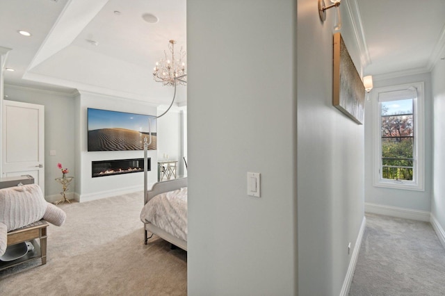 bedroom featuring carpet, a chandelier, a tray ceiling, and ornamental molding