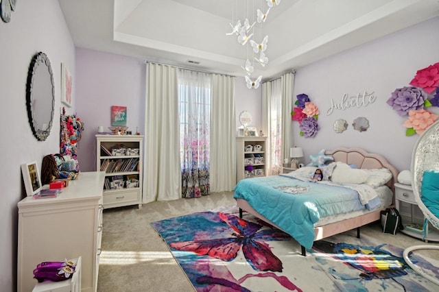 carpeted bedroom with a tray ceiling