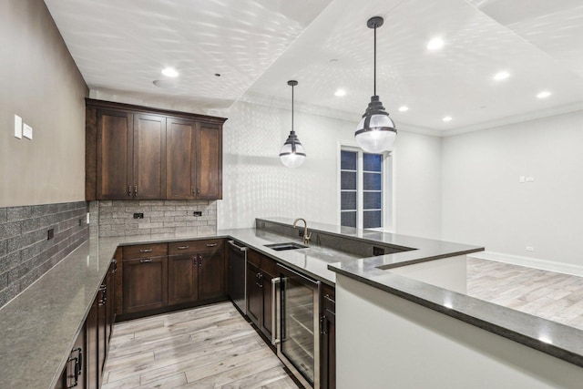 kitchen featuring light wood-type flooring, wine cooler, ornamental molding, pendant lighting, and sink