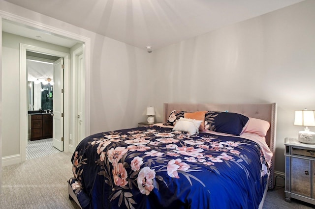 bedroom featuring ensuite bath and carpet flooring