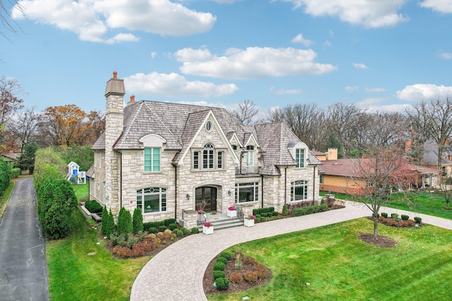 french country style house with a front lawn