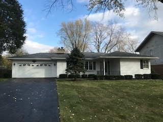 ranch-style house with a garage and a front yard