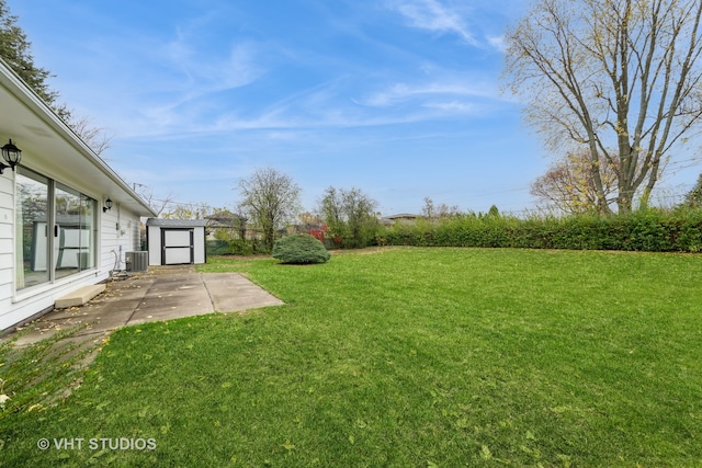 view of yard with a storage unit, central AC unit, and a patio area