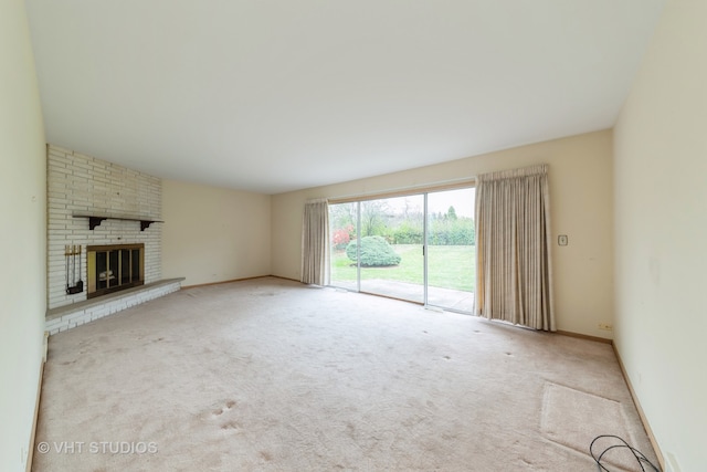 unfurnished living room with light colored carpet and a brick fireplace