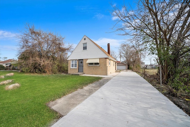 bungalow-style home with brick siding, a chimney, a detached garage, an outbuilding, and a front yard