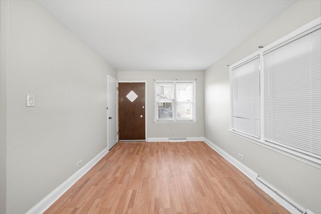 entryway with a baseboard heating unit, light wood finished floors, baseboard heating, and baseboards