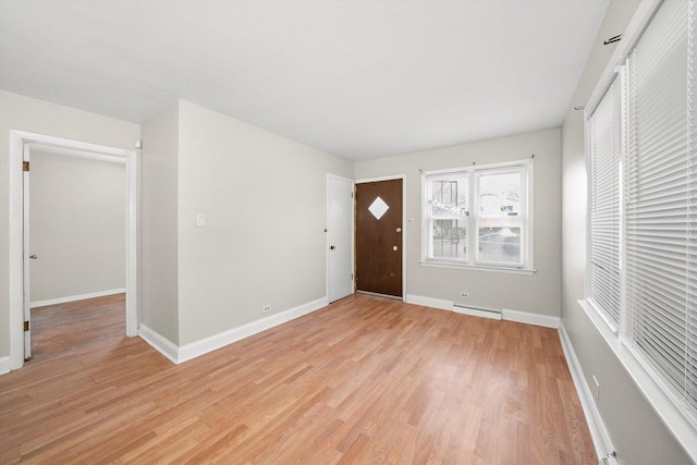 foyer featuring light wood-type flooring, a baseboard radiator, and baseboards