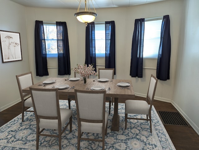 dining area featuring dark hardwood / wood-style flooring and crown molding