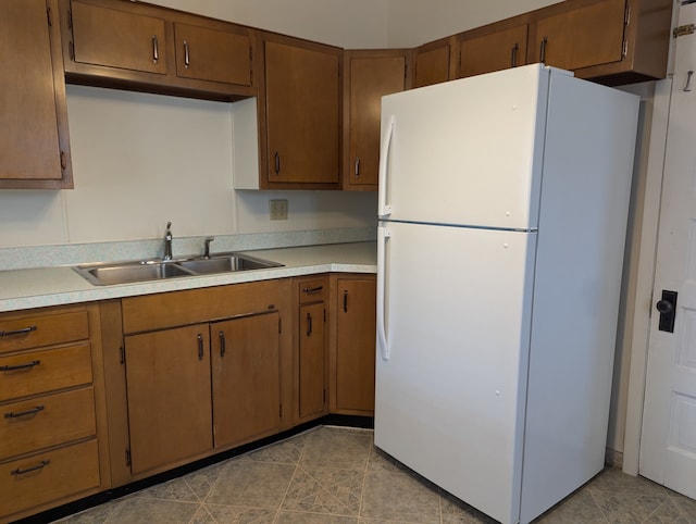 kitchen with sink, white fridge, and light tile patterned flooring