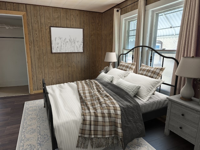 bedroom with wooden walls and dark hardwood / wood-style floors