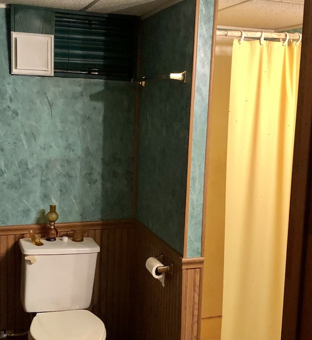 bathroom featuring toilet and wooden walls