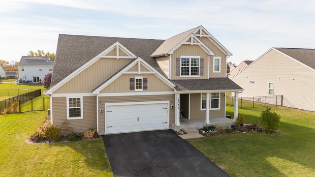 craftsman-style house featuring covered porch, a garage, and a front lawn