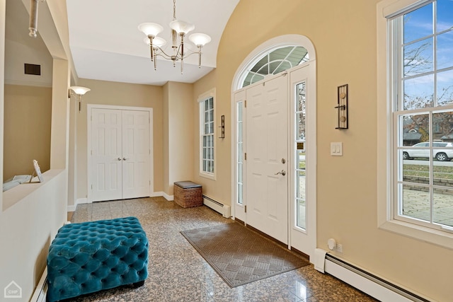 entryway with plenty of natural light, baseboard heating, and a notable chandelier