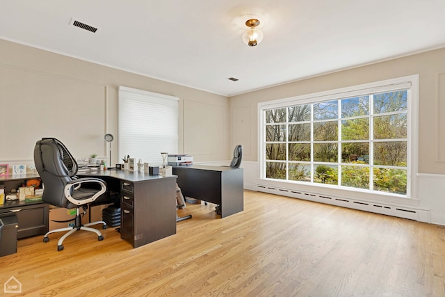 office space with baseboard heating and light hardwood / wood-style flooring