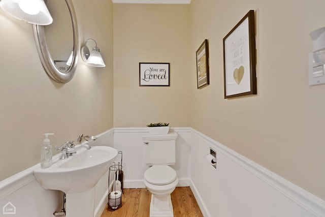 bathroom with hardwood / wood-style floors and toilet