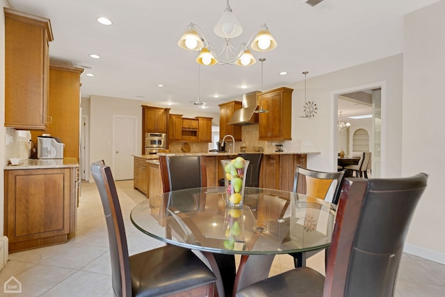 dining space with a chandelier, light tile patterned floors, and sink