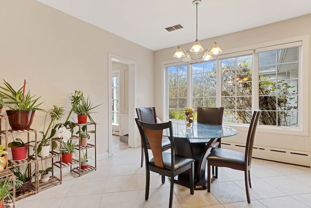 tiled dining room featuring a chandelier and a baseboard radiator