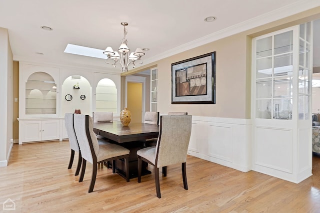 dining area featuring crown molding, a chandelier, and light wood-type flooring