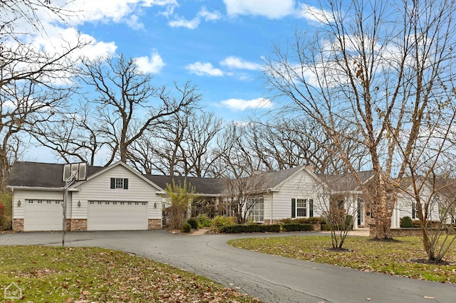 ranch-style house featuring a garage and a front yard