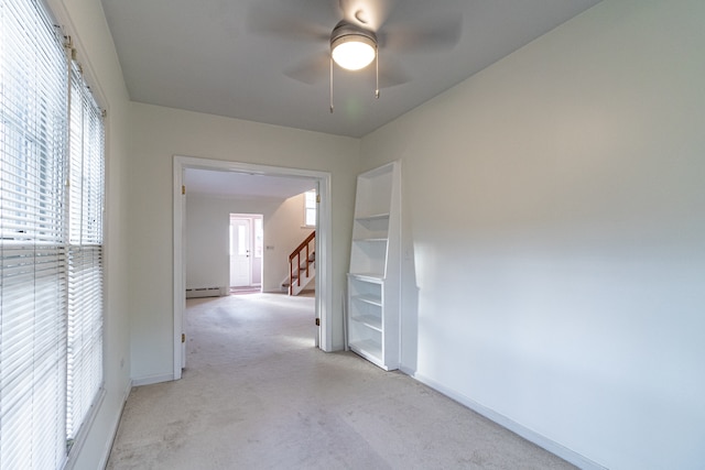 corridor featuring light carpet and a baseboard heating unit