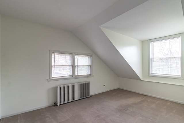 bonus room featuring radiator heating unit, light colored carpet, and plenty of natural light