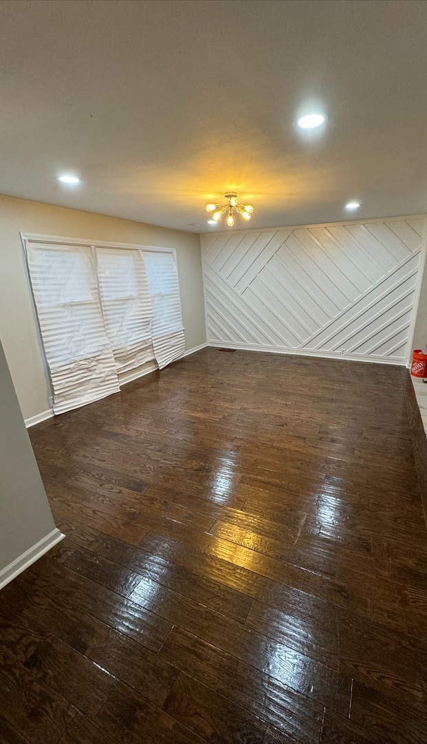 unfurnished room featuring wooden walls and dark wood-type flooring