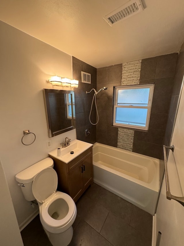 full bathroom featuring tile patterned flooring, vanity, tiled shower / bath combo, and toilet