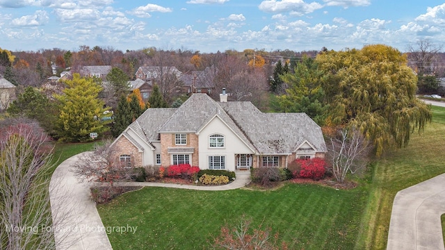 view of front of home featuring a chimney, a front yard, and stucco siding