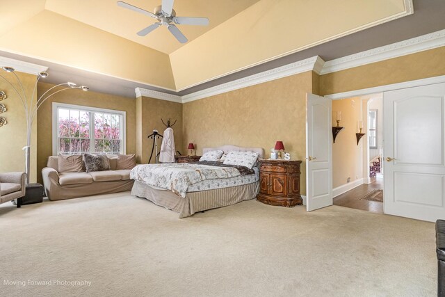 carpeted bedroom featuring a raised ceiling, crown molding, and a ceiling fan