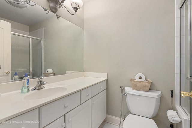 bathroom featuring tiled shower, baseboards, vanity, and toilet