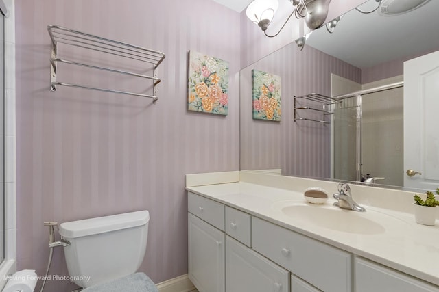 full bath featuring a tile shower, toilet, vanity, and wallpapered walls