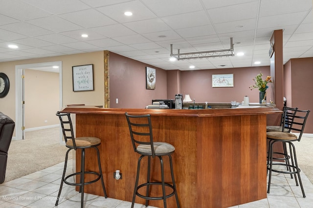bar with recessed lighting, a bar, baseboards, a paneled ceiling, and light colored carpet
